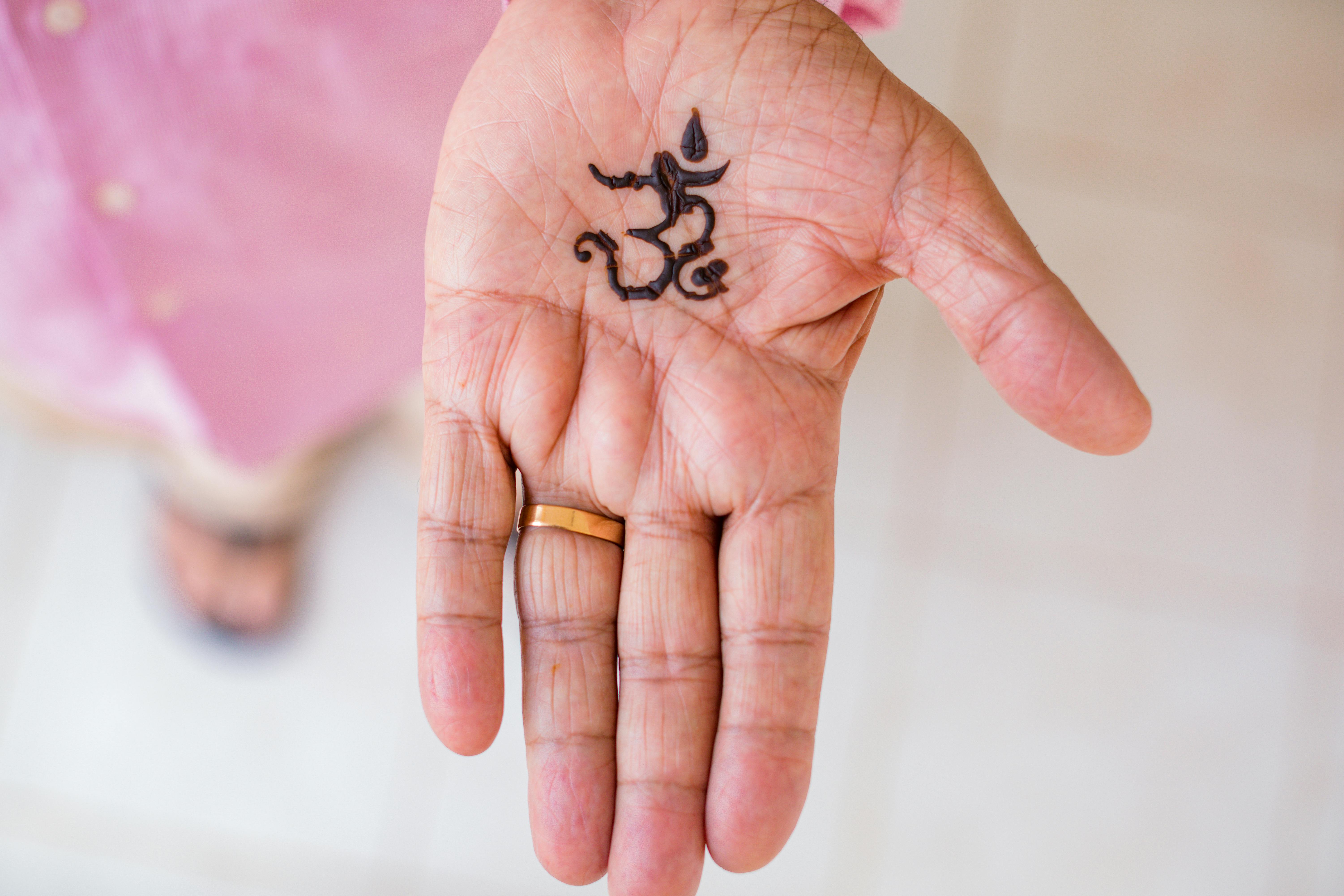 A Person with Henna Tattoo on the Hand Wearing Gold Ring · Free Stock Photo