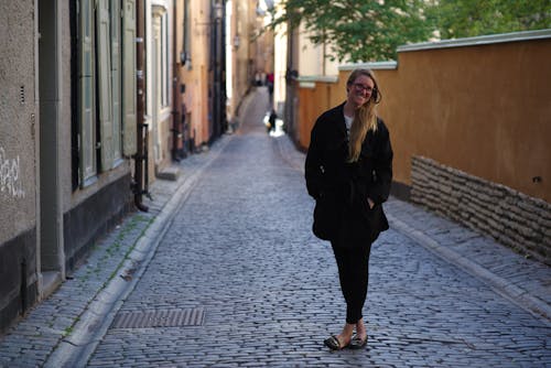 A Woman in Black Coat Standing on the Street