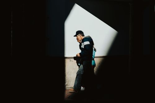 Free A man walks through a stark shadowy path in Bogotá, Colombia. Urban and moody. Stock Photo