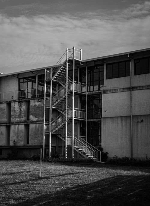 Free Monochrome photo of a building exterior with metal stairs and windows. Stock Photo