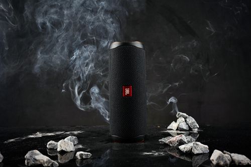 Free Close-up of a cylindrical speaker on a dark background with smoke and rocks. Stock Photo