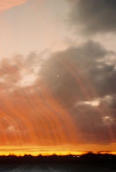 Captivating orange sunset with clouds and horizon silhouette, perfect for peaceful evening themes.