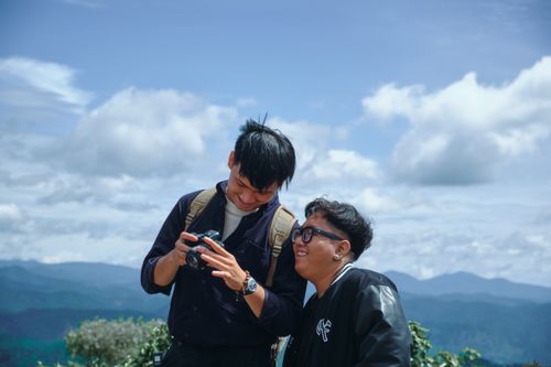 Free Two friends enjoying a nature hike with a camera, capturing moments in the mountains. Stock Photo