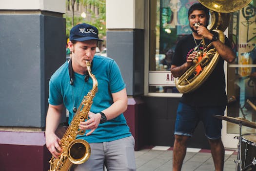 Musicians performing with saxophone and tuba on a city street.