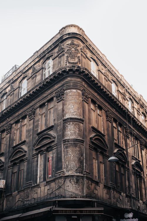 Free A low-angle view of an ornate historical building showcasing intricate architectural details and aged facade. Stock Photo
