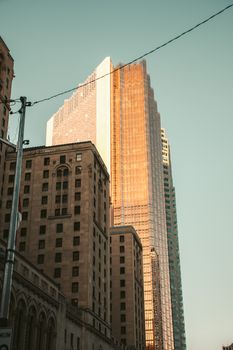 Toronto skyline highlighted by a golden skyscraper during daylight, showcasing urban architecture.