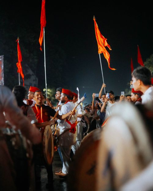 Free A lively festival parade at night featuring people with drums and flags, creating a festive atmosphere. Stock Photo