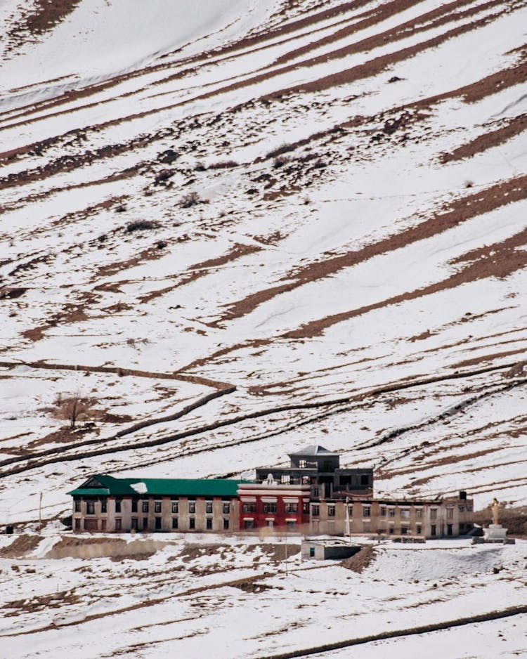 Buildings Under Hill In Snow