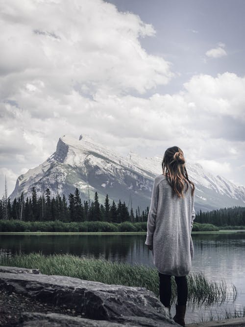 Free Woman Standing Near Rock in Front of Lake Stock Photo