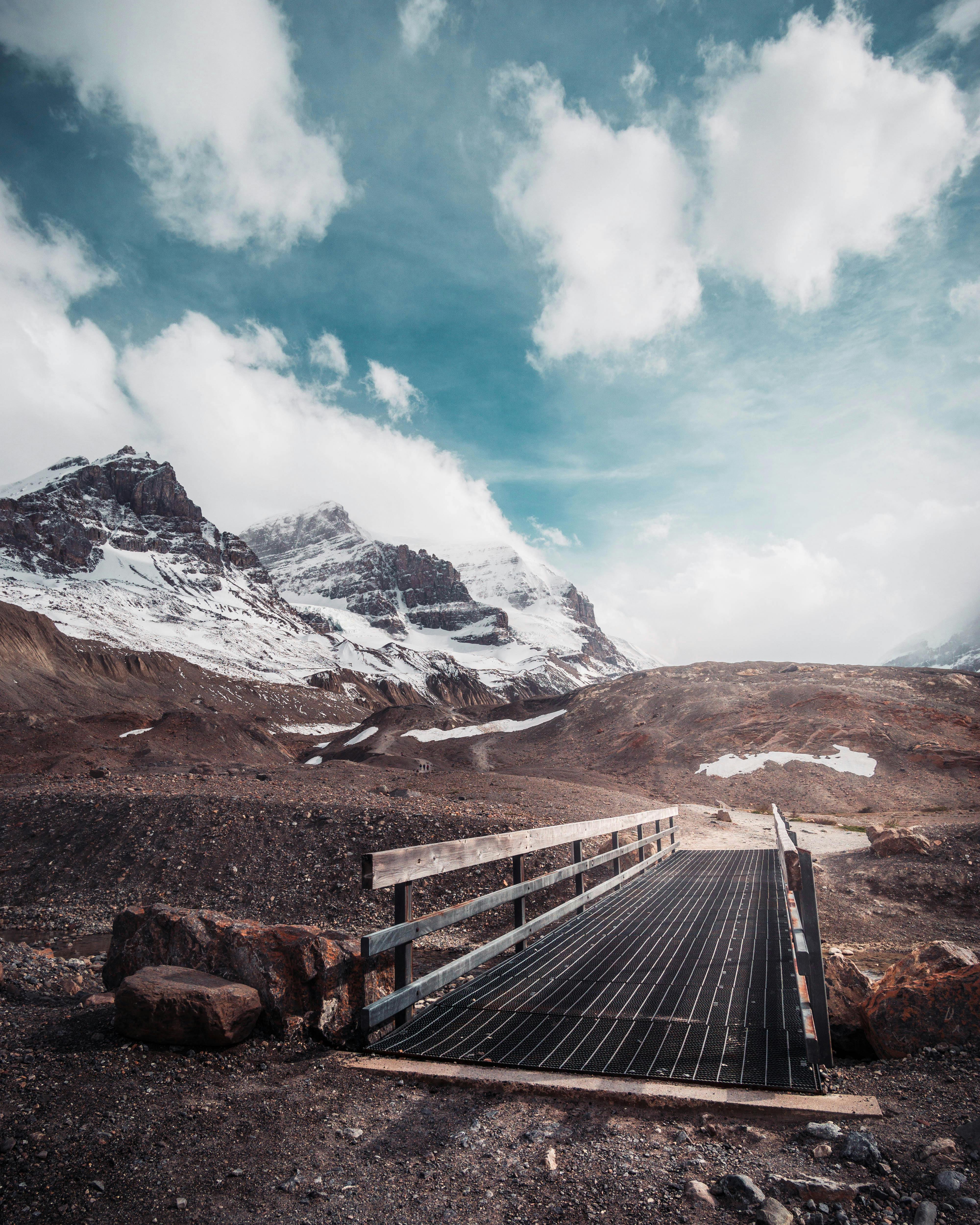 在充满活力的蓝天下，探索一座木桥上宁静的山脉全景