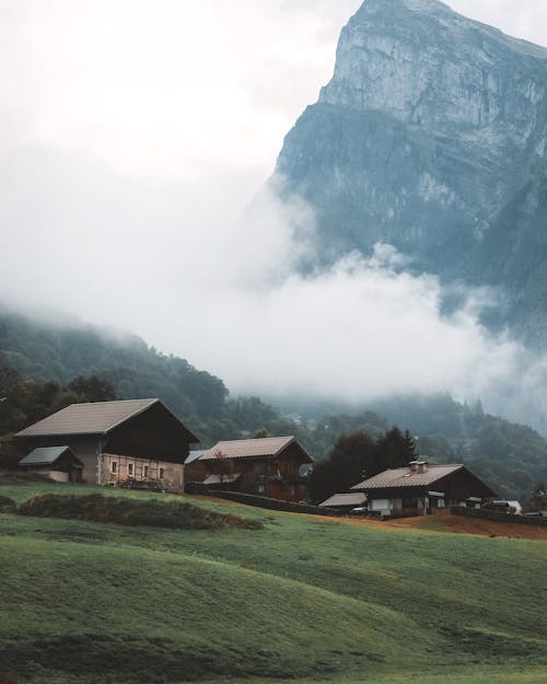 View of Houses in a Mountain Valley and a High Rocky Mountain in the Background