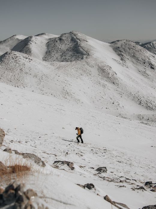 Solitary hiker crossing a snowbound slope — photo by Dajana Reçi on Pexels