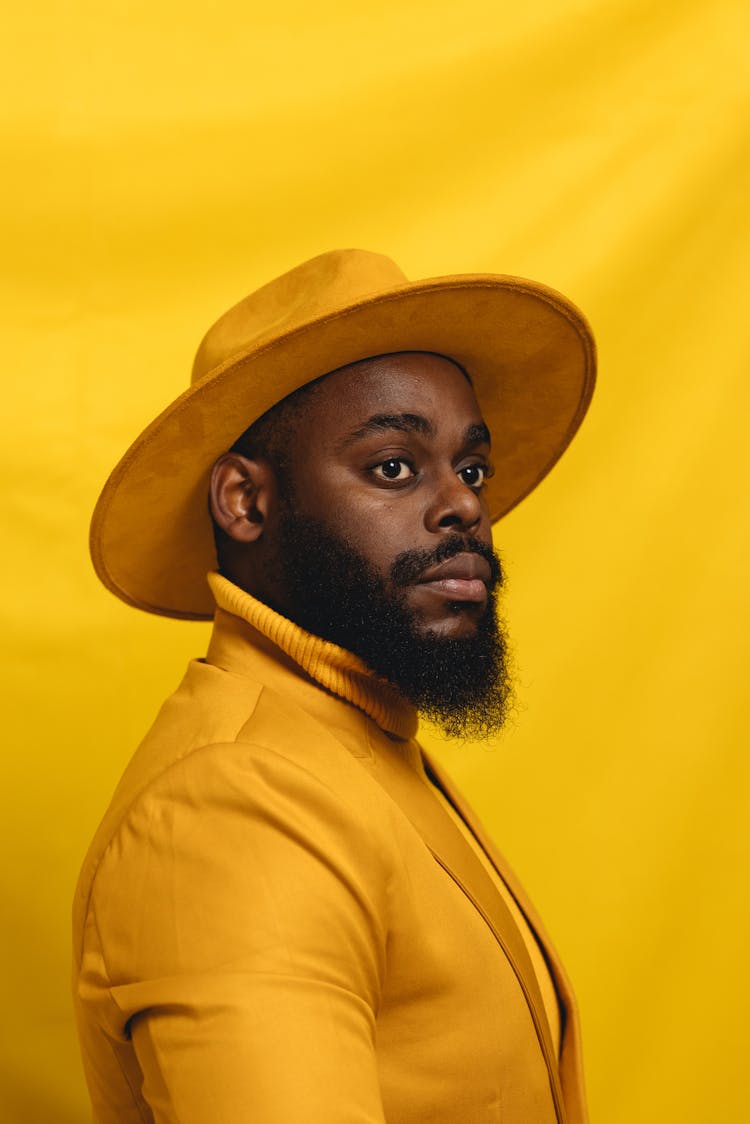 Man Wearing A Yellow Outfit Posing On Yellow Background 