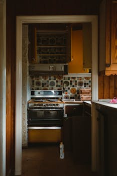 Cozy retro kitchen featuring vintage tiles, stove, and bold yellow cabinetry.