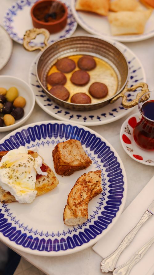 Free A close-up of a traditional Turkish breakfast featuring tea, olives, and pastries. Stock Photo