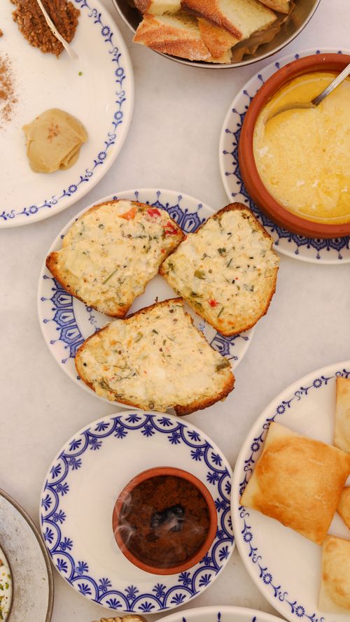 Free Top view of assorted bread with cheese and dipping sauces, perfect for a savory breakfast or snack. Stock Photo