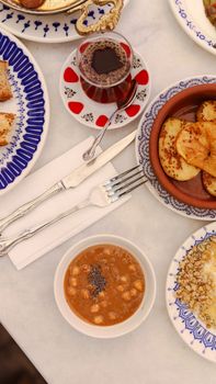 A delicious Middle Eastern breakfast spread with chickpeas, bread, and tea on a beautifully set table.