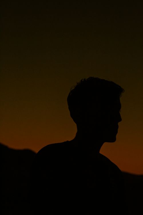 Free A striking silhouette of a man during twilight creating a dramatic and moody atmosphere. Stock Photo