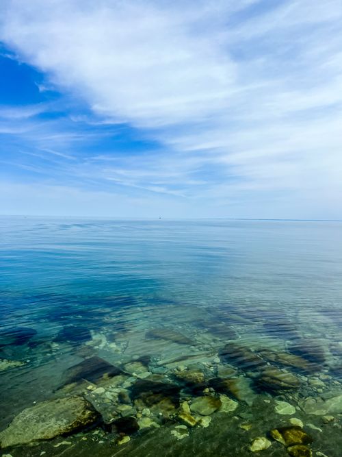 Free Serene view of Lake Ontario's calm waters and clear sky in Toronto, Canada. Stock Photo