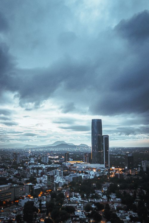Free Stunning aerial view of a city skyline with skyscrapers under a dramatic twilight sky. Stock Photo