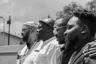 Black and white portrait of four African men standing together outdoors, symbolizing unity and friendship.