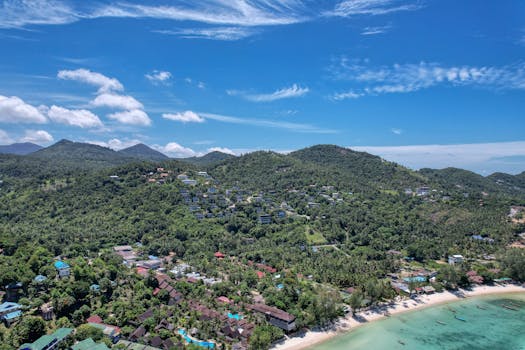 Stunning aerial view of Ko Pha-ngan's lush hills and clear beaches in Thailand.