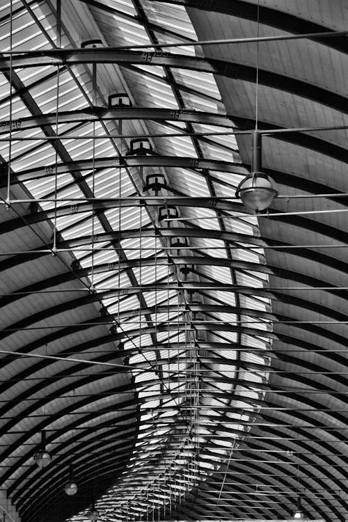 Grayscale Photo of Pendant Lamp Inside Stadium