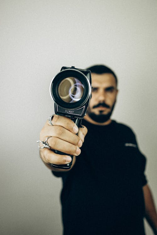 Homem De Camisa Preta De Gola Alta E Manga Comprida Segurando Câmera Preta