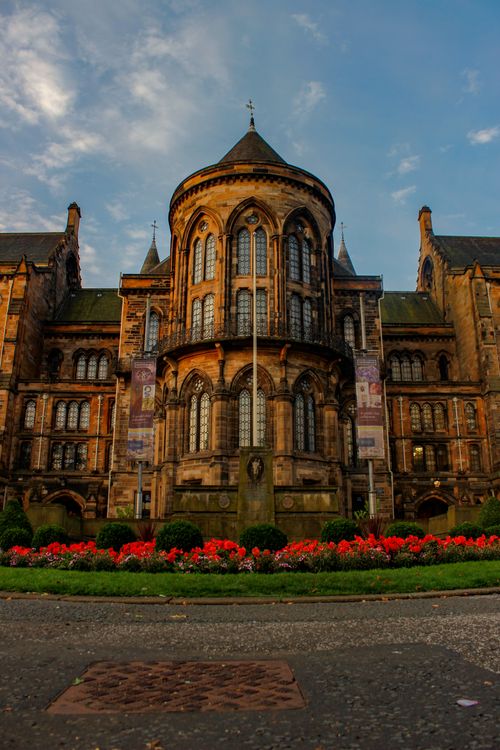 Free Photo of University of Glasgow showing its stunning Gothic architecture under a blue sky. Stock Photo