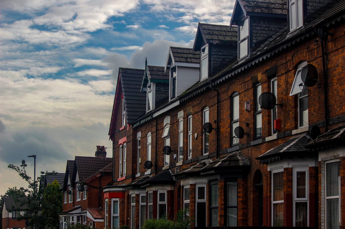 Traditional brick row houses in a northern English suburb under a cloudy sky