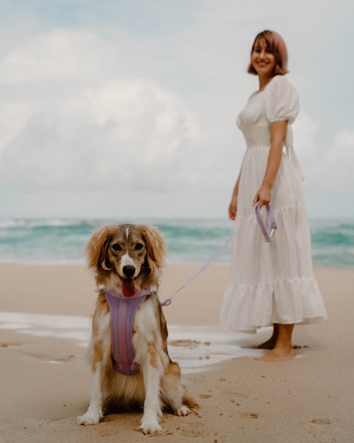 Smiling Woman with Her Australian Shepherd Dog on the Beach 