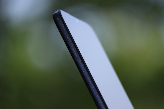 Side view of a sleek smartphone with a blurred green background, highlighting its slim design and buttons.