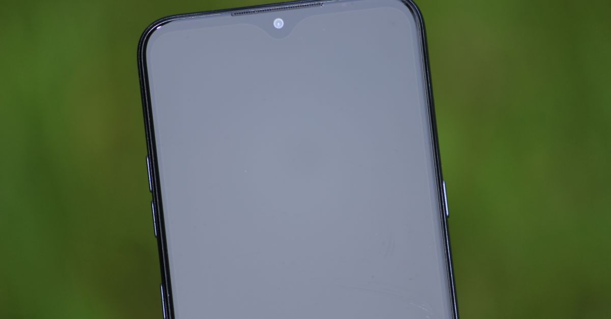 Visão aproximada da tela de um smartphone com fundo verde, ideal para temas tecnológicos.