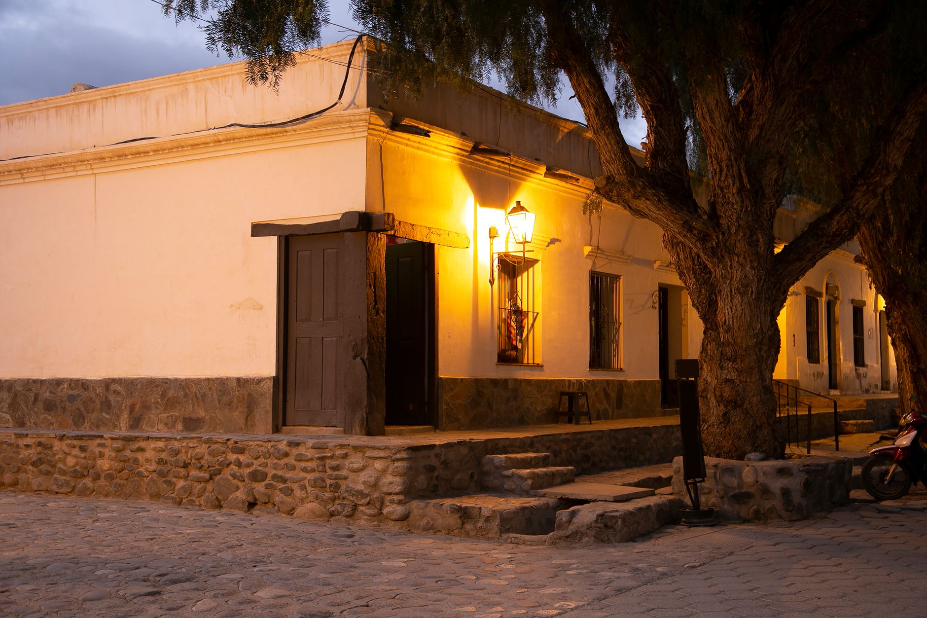 Charming street corner in Cachi, Salta, Argentina, featuring a lit facade at twilight.