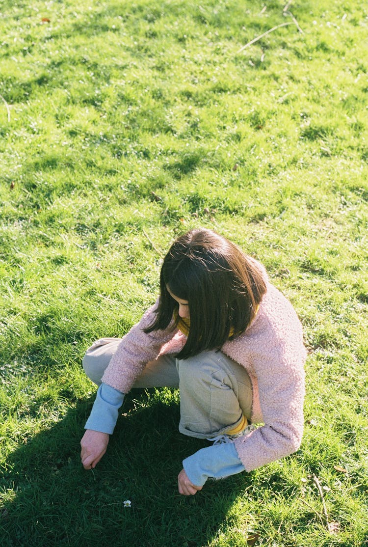 Woman Picking Grass On Green Grass Field