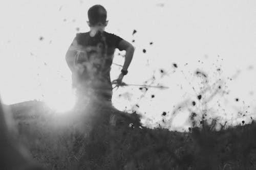 Grayscale Photo of a Person Standing on a Field