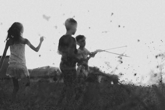 Black and white photo of children playing in a grassy field in Aracati, Brazil.
