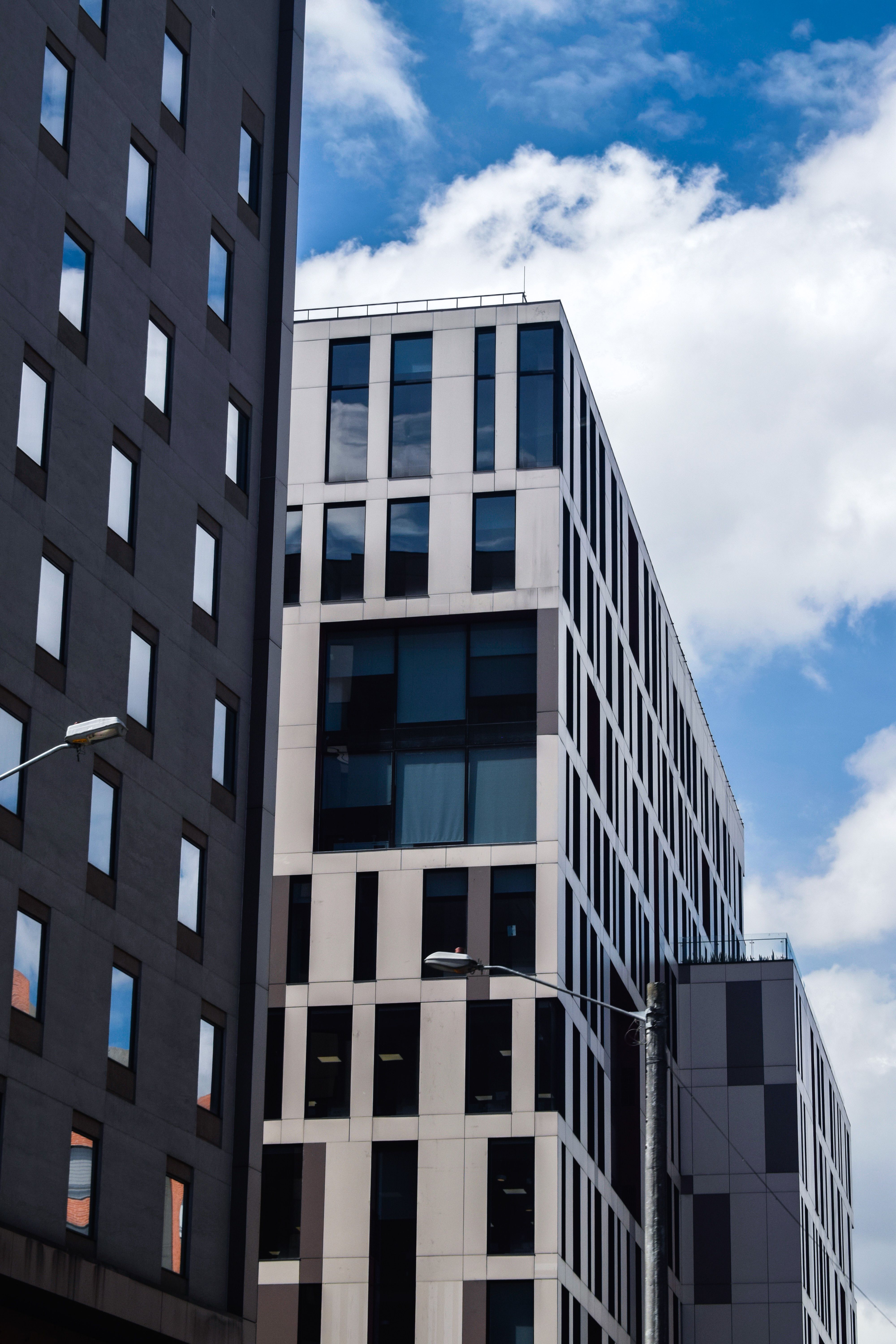 A Low Angle Shot of a Building Under the Blue Sky and White Clouds ...