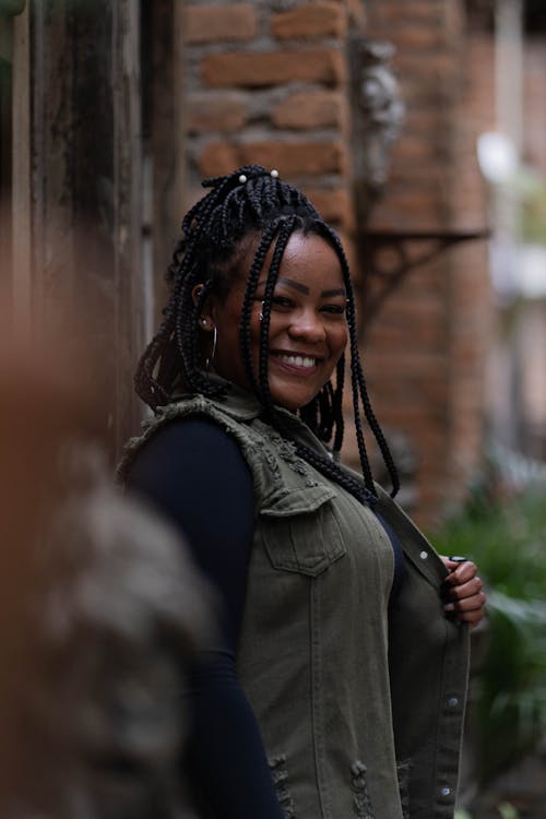 A Woman in Black Long Sleeves with Gray Vest Smiling