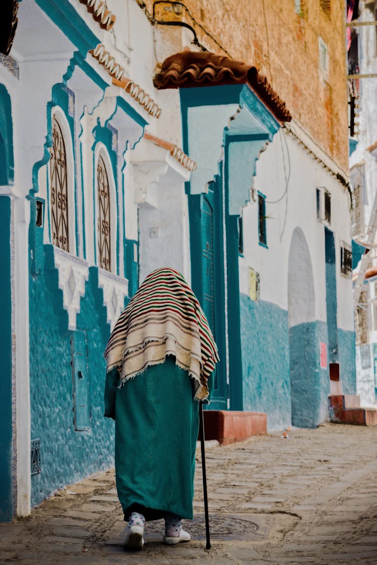 Back View Of An Elderly Woman Walking With A Walking Stick