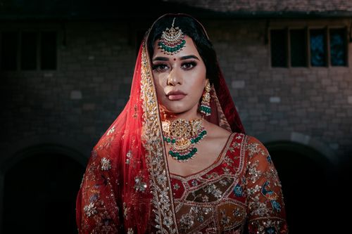 Free Elegant portrait of a woman in traditional attire with intricate jewelry and a red veil. Stock Photo