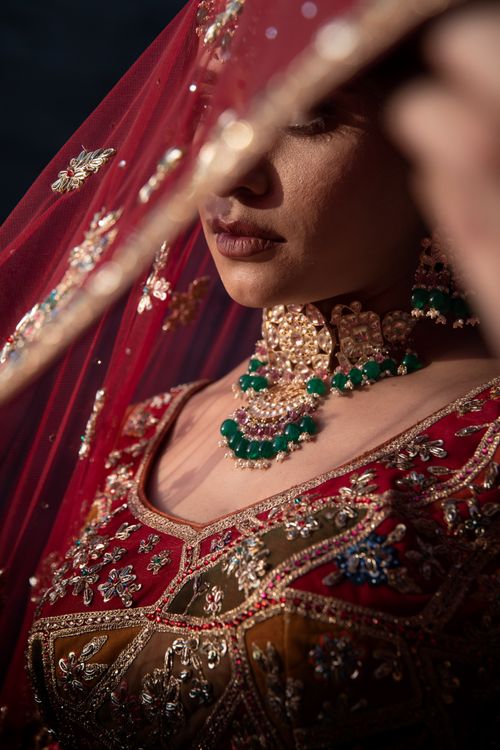 Free Asian bride in luxurious red and gold traditional dress with emerald jewelry and veil. Stock Photo