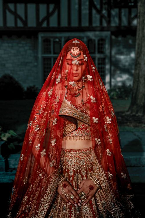 Free Stunning Indian bride in intricate red lehenga and jewelry, capturing cultural elegance. Stock Photo