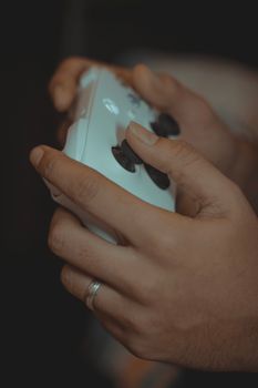 Detailed close-up of hands playing with a video game controller.