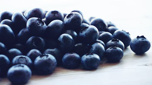 Free Blueberries Lot Above Beige Wooden Surface Stock Photo