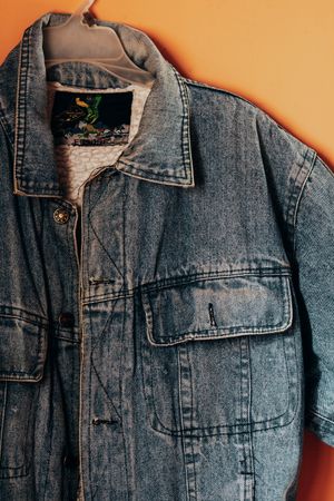 Denim jacket hanging against a warm wall — photo by Arturo A&ntilde;ez on Pexels