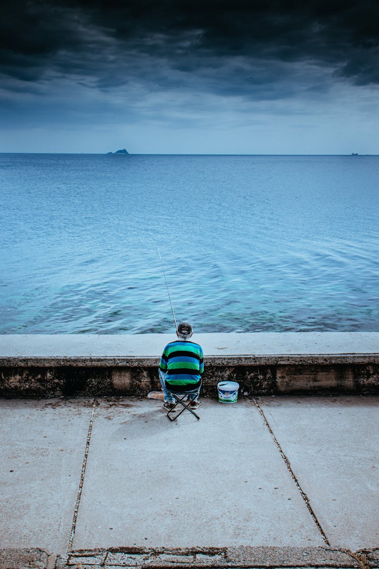 A Man Fishing On The Bay