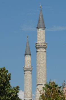 Vertical shot of iconic minarets in Istanbul, Turkey, under a sunny blue sky.
