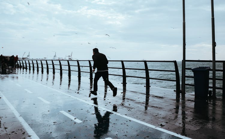 A Person Running On A Wet Dock