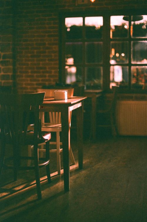 Free A warm, cozy café interior with wooden furniture and ambient lighting creates a charming atmosphere. Stock Photo